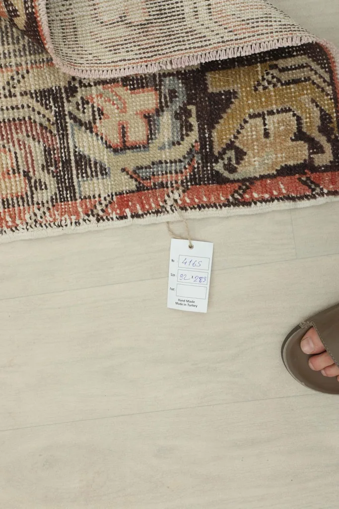 Close-up of the rug's edge with a product tag, showing the reverse side of the border