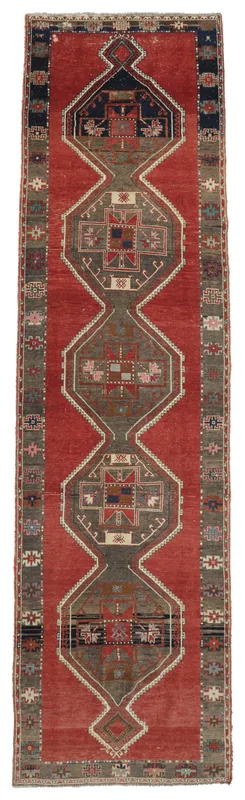 Full overhead view of the rust and gray geometric vintage Anatolian runner rug on a white background.