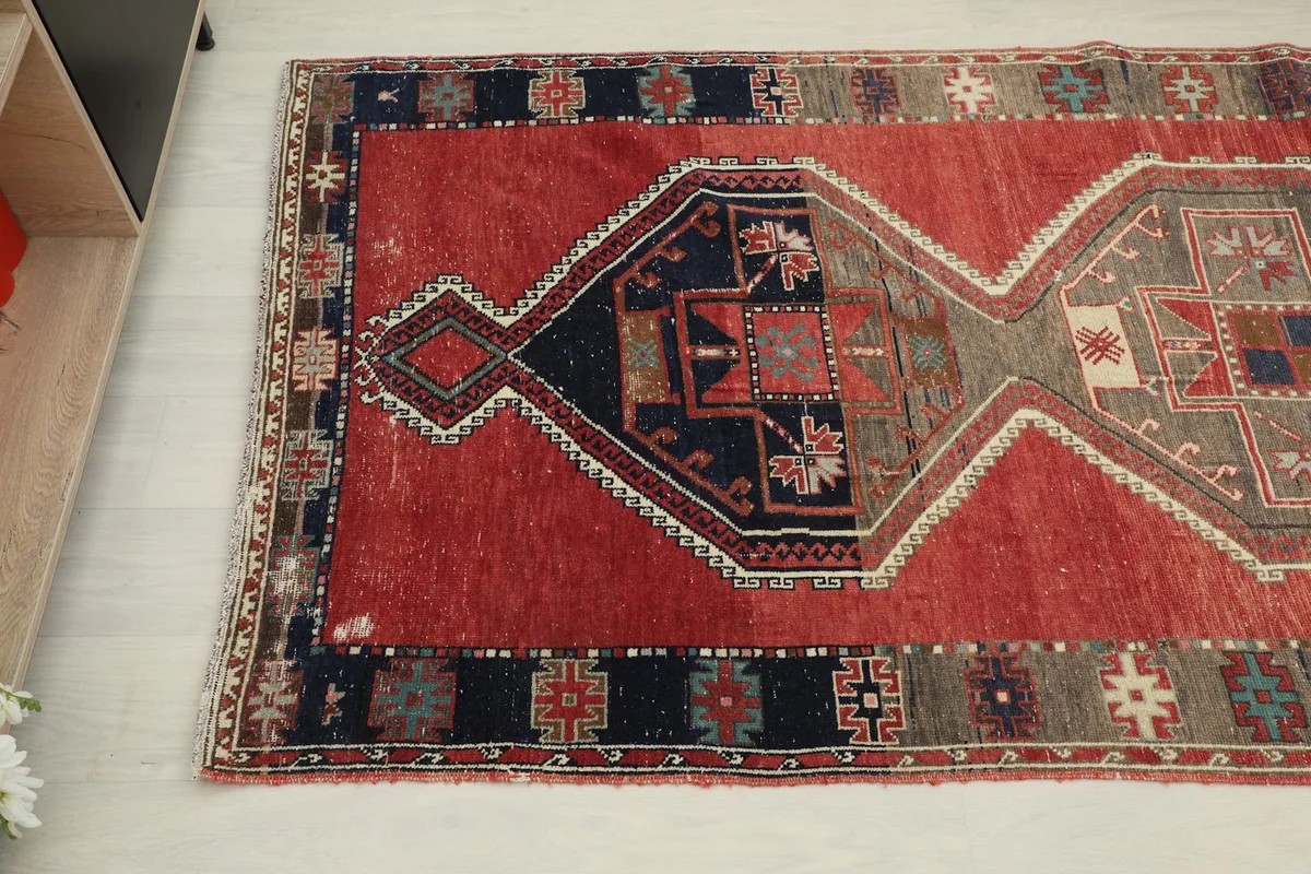 Angled view focusing on the end of the runner, showing the navy and gray border details and rust field.