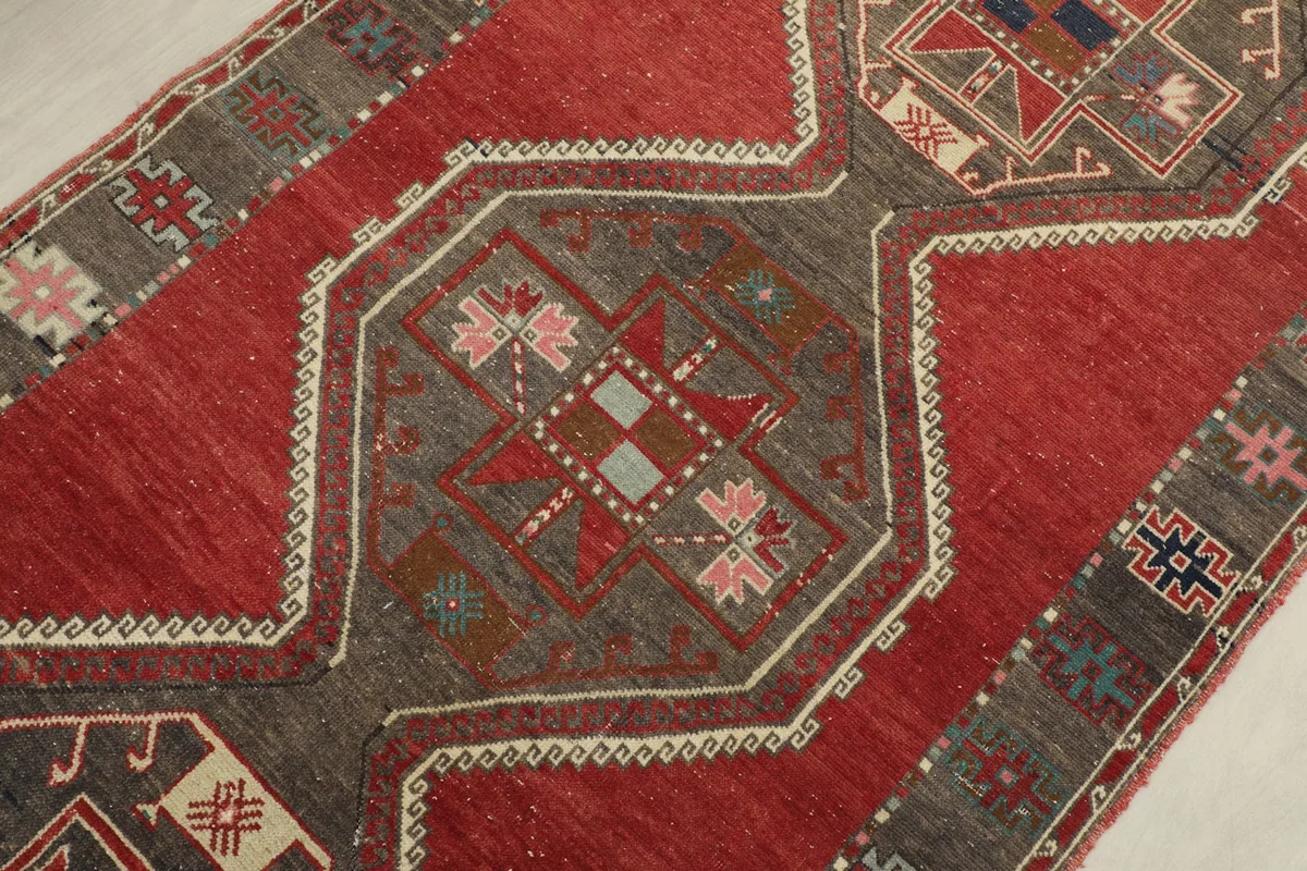 Detailed close-up of a central gray geometric motif with accents of red, pink, and light blue within the runner.