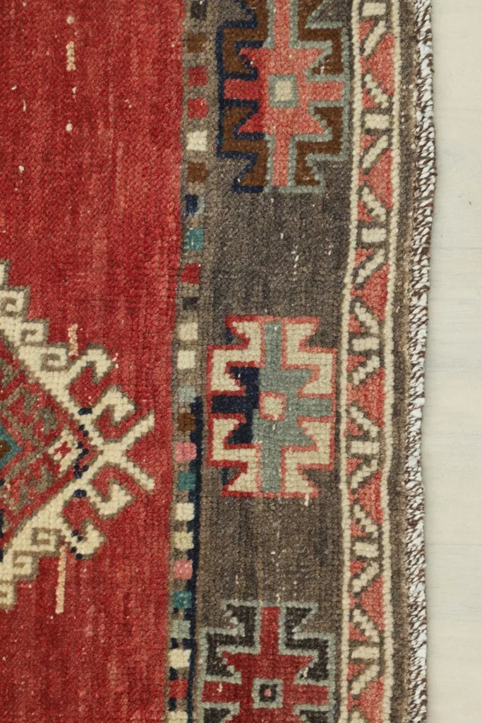 Close-up view of the side border with geometric patterns and the subtle fringe of the hand-knotted runner.