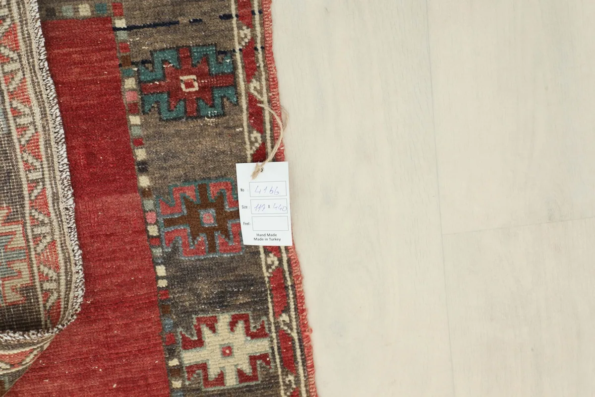 Detailed view of the rug's reverse side, showcasing the hand-knotted construction and a product tag.