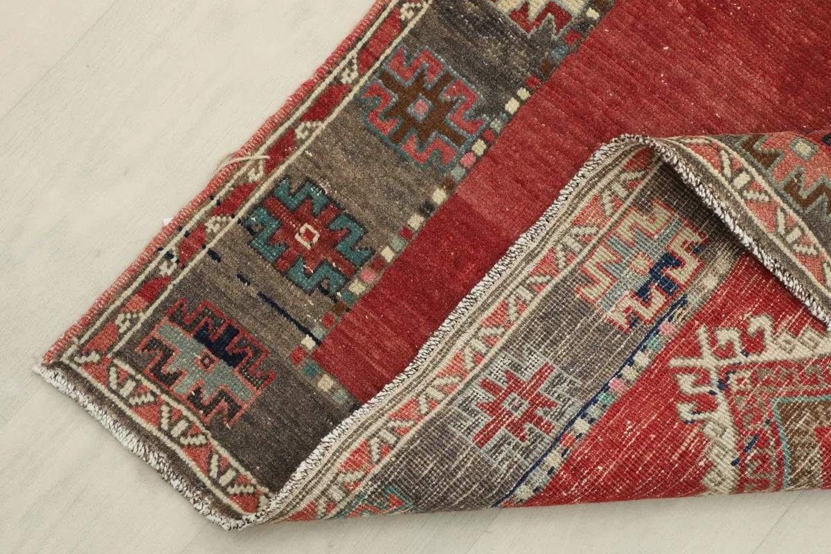 Close-up of the runner's corner folded back, revealing the wool pile on cotton foundation and intricate knotting.