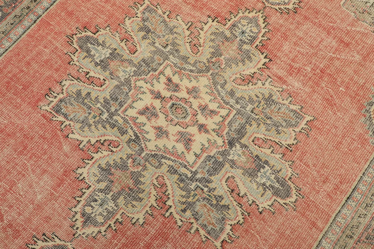 Detailed view of the central medallion with beige, gray, and blue tones