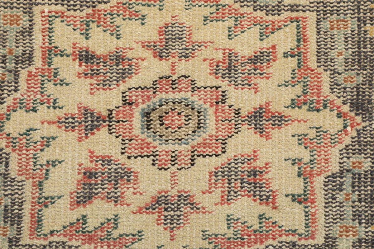 Close-up of the intricate patterns and knotting in the rug's border