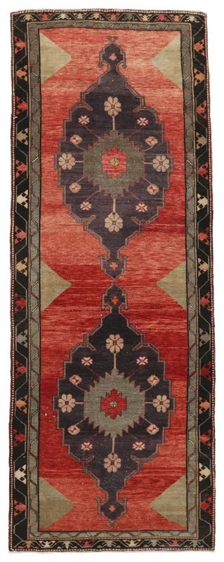 Full top view of a vintage Anatolian runner rug with rust field and navy medallions