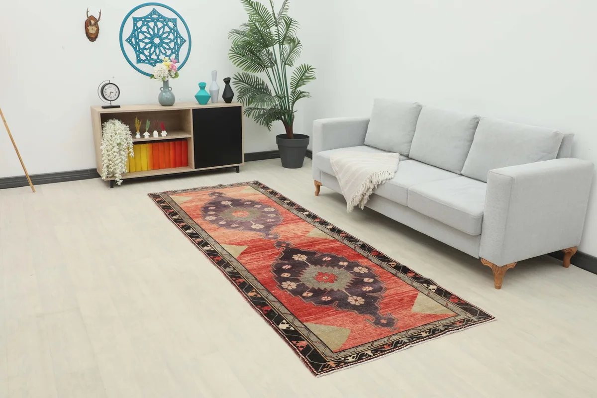 Runner rug displayed in a living room setting next to a gray sofa and wooden cabinet