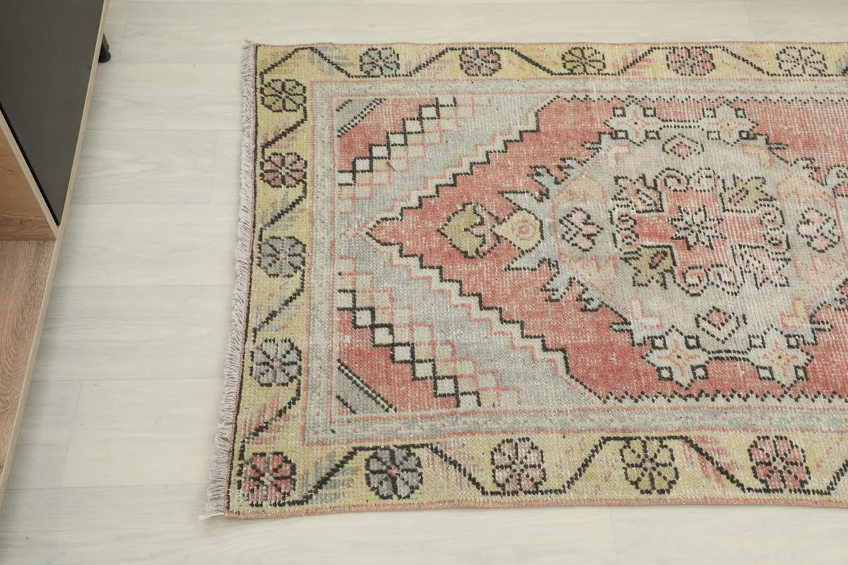 Close-up angle view of the other end of the vintage runner rug, showing the border detail