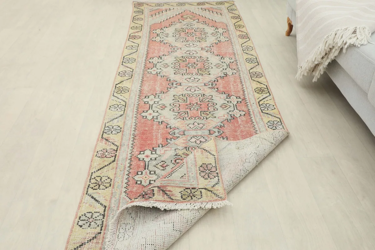 The runner rug partially folded, showing the flexibility and thickness of the wool pile