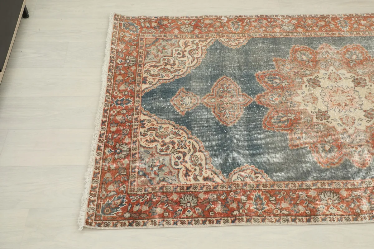 Another corner angle of the rug, showing the blend of rust, blue, and ivory colors in the design