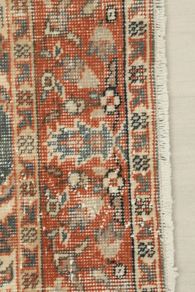 Detailed view of the rug's border and fringe, showing the hand-knotted texture and wool pile