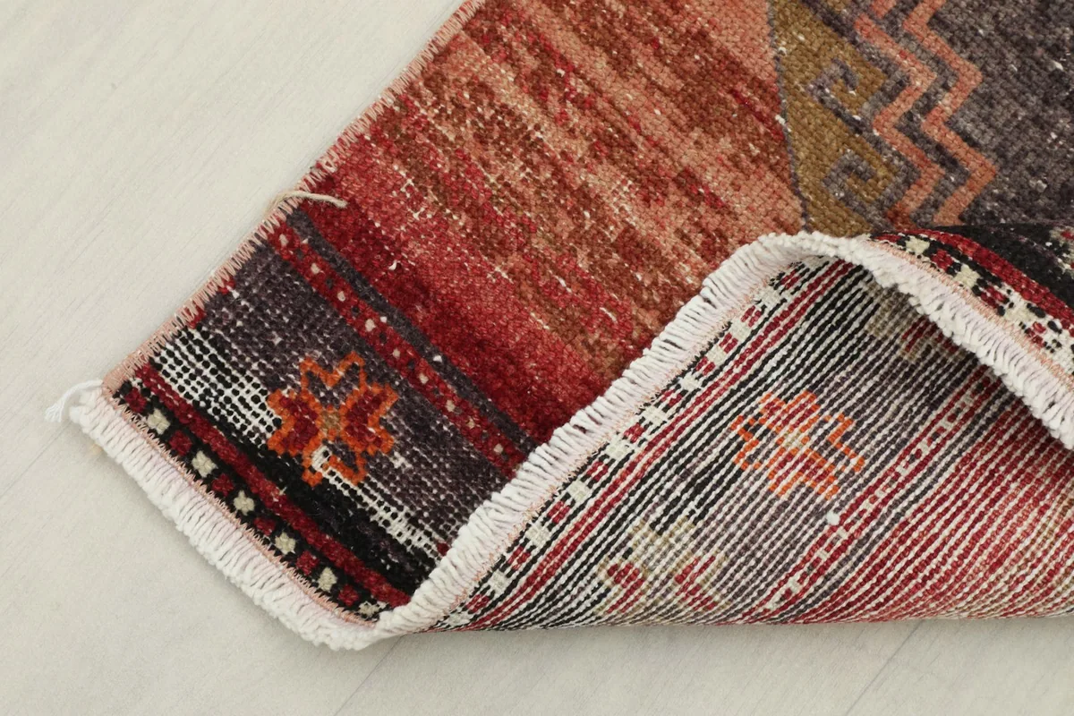 Corner of the rug folded back to reveal the hand-knotted cotton foundation and wool pile