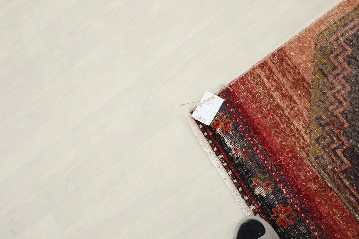 Top-down view of the rug's corner with a small tag, showing the natural fringe