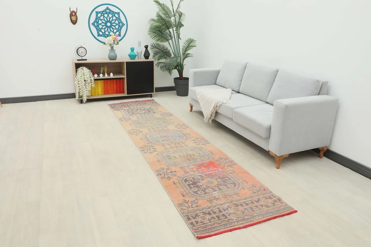 Vintage Anatolian runner rug laid out in a modern room setting with a sofa