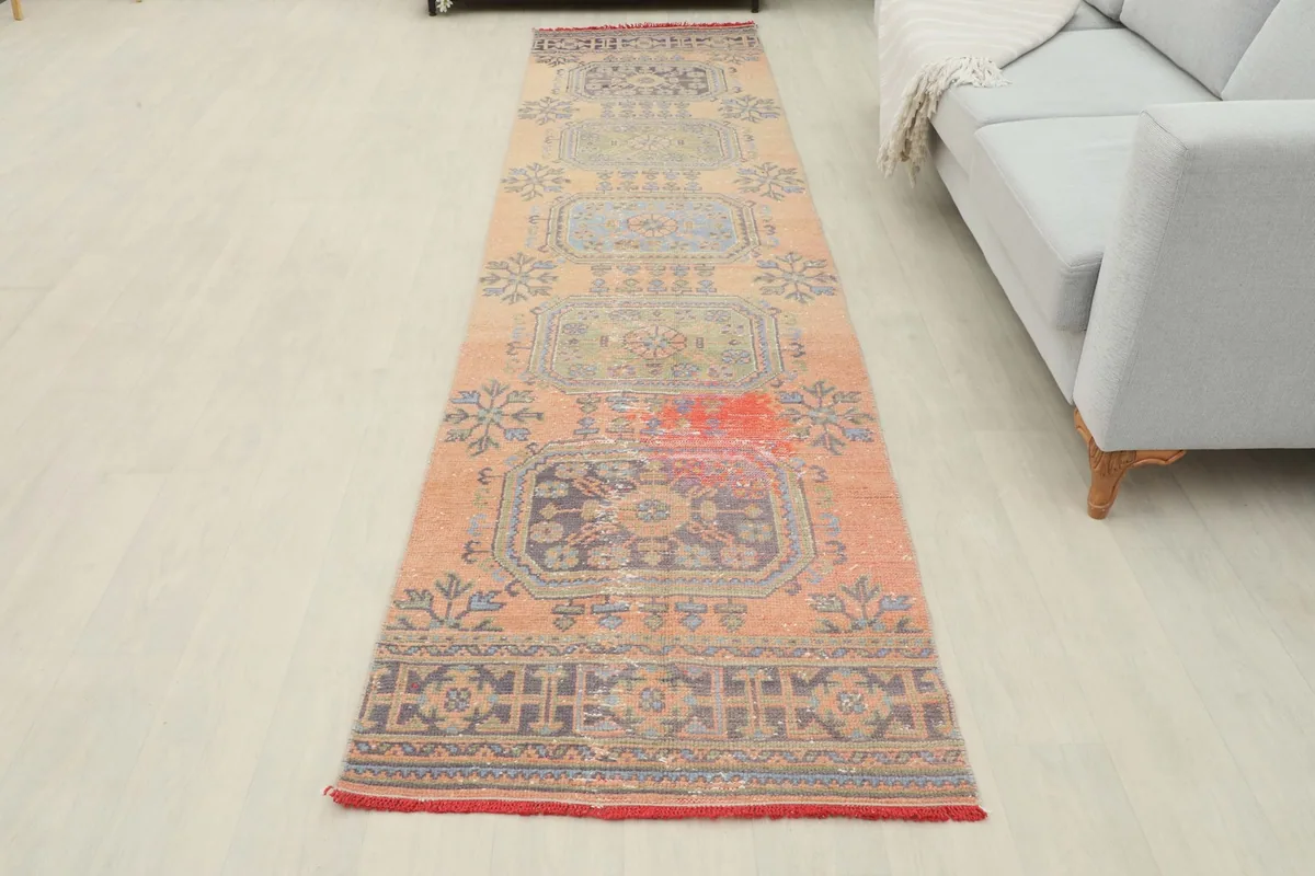 Full view of the vintage runner rug in a room, showcasing its unique character and color palette