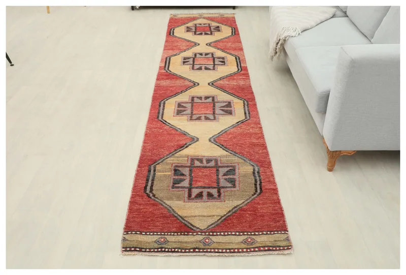 Full top view of the 2'6" x 11'5" red and beige geometric Anatolian runner rug on a white background.