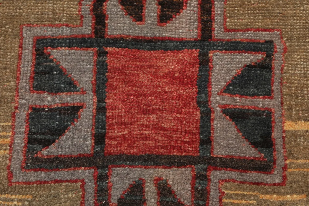 Extreme close-up of a central geometric design, revealing the hand-knotted wool pile and color variations.
