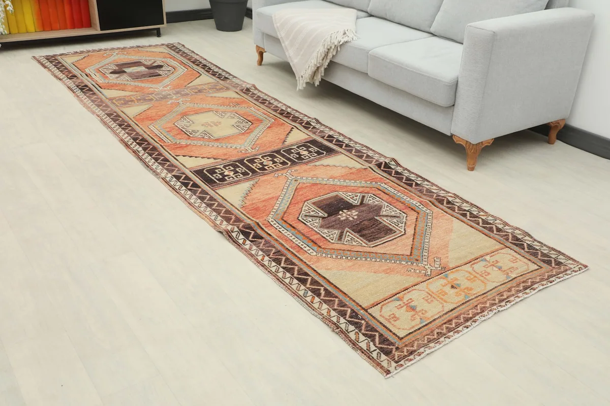 Angled view of the rust and beige runner rug extending from a sofa in a living space