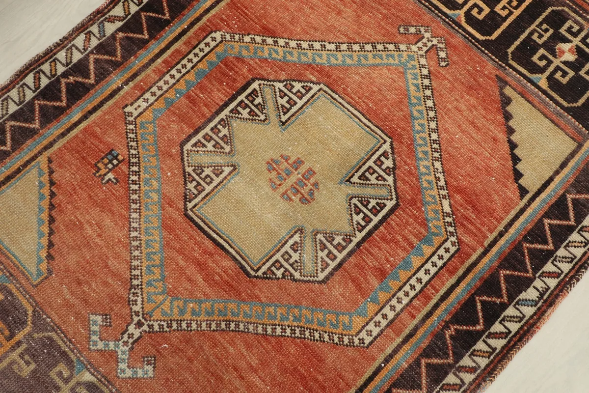 Detailed close-up of a central geometric medallion and surrounding rust field