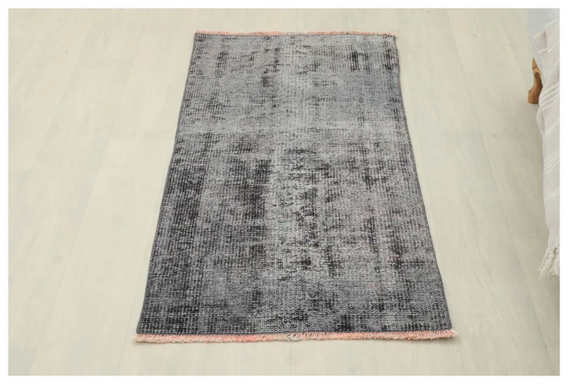 Full top view of the 2x4 gray and charcoal distressed vintage rug on a white background