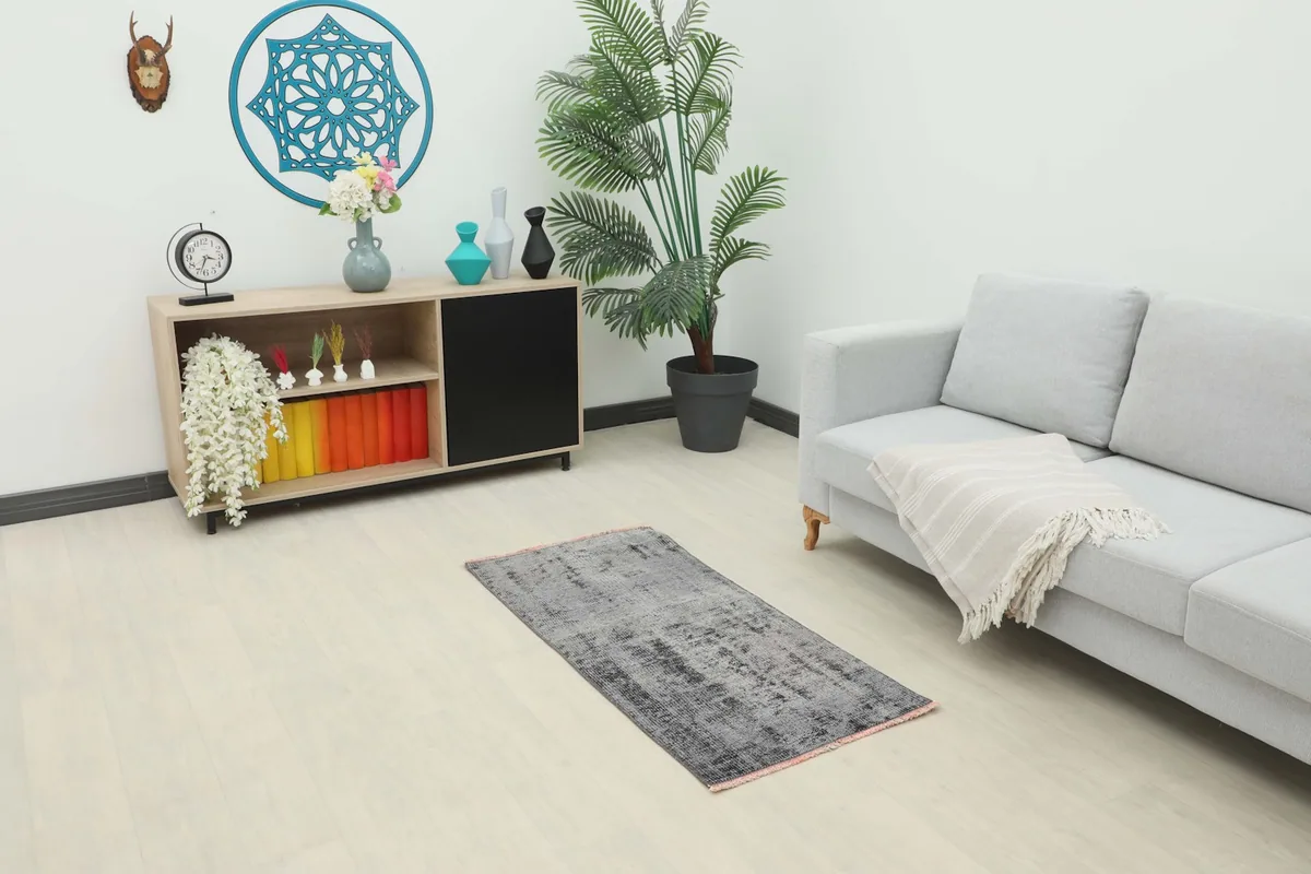 Vintage gray and charcoal rug placed in a modern living room setting with a light gray sofa
