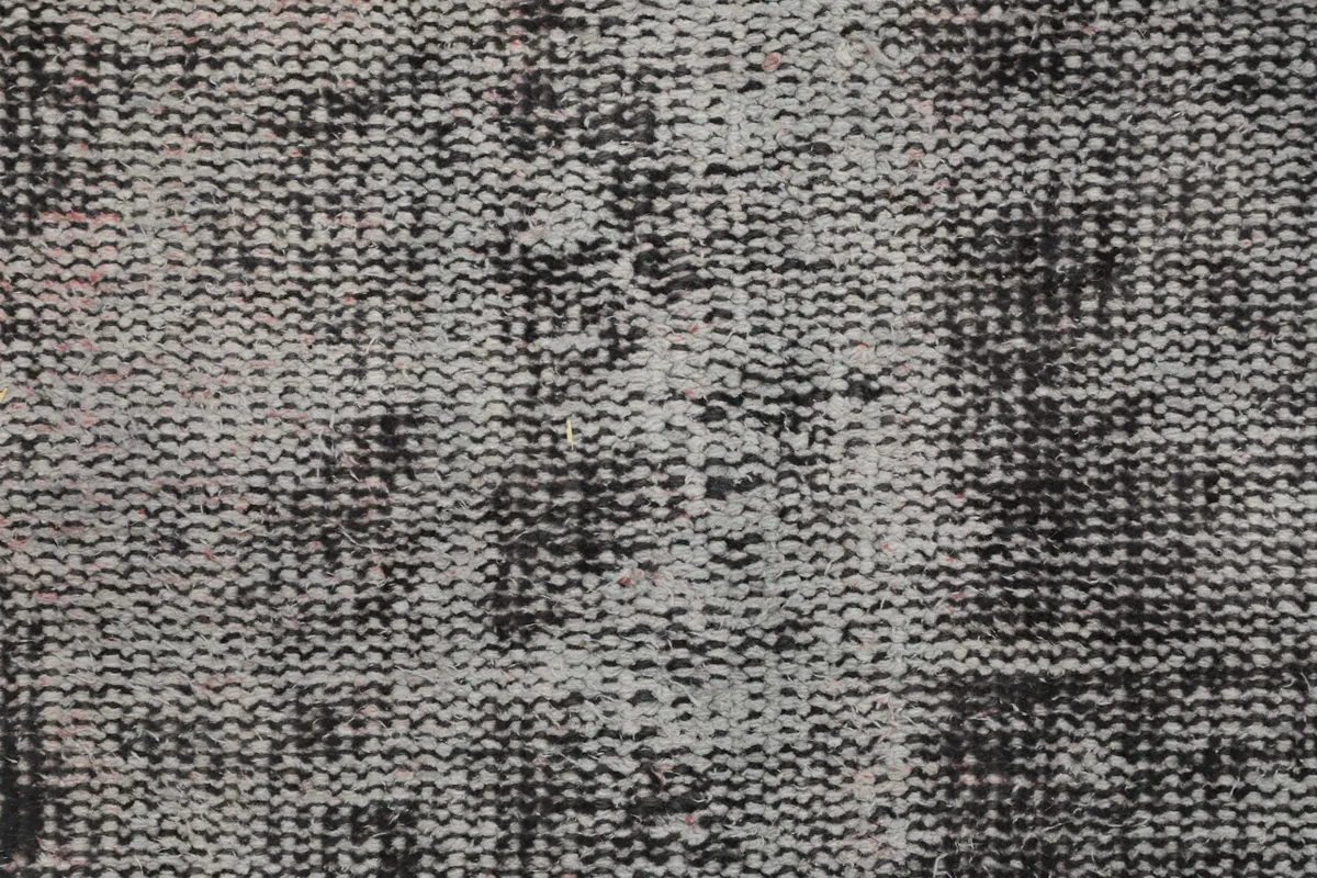 Extreme close-up of the low wool pile, revealing individual knots and muted colors