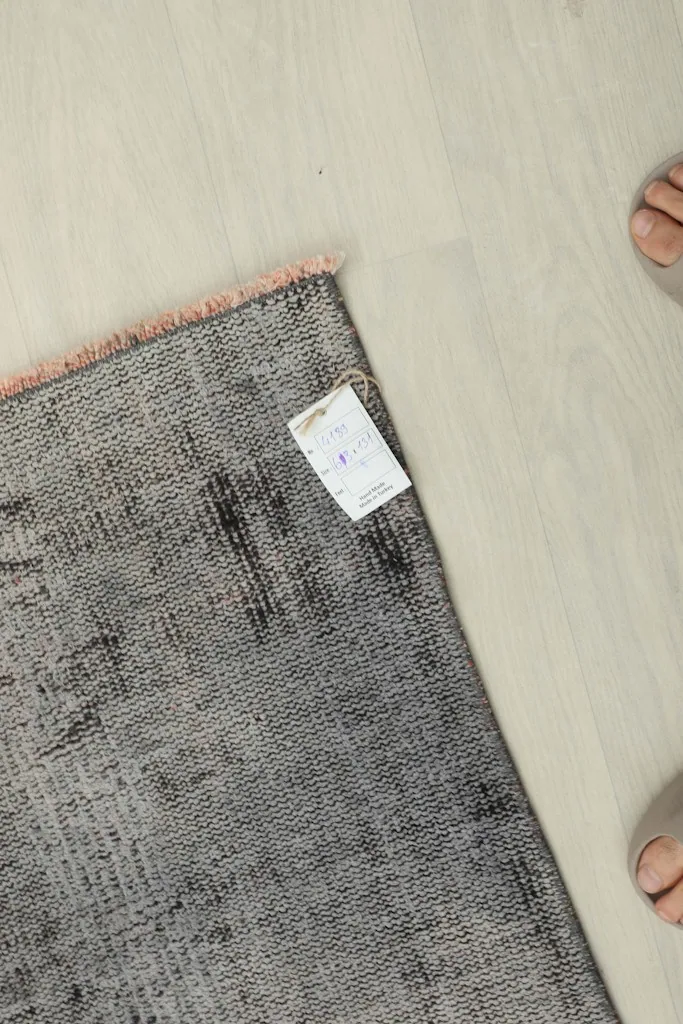 Overhead view showing the rug with a label, highlighting its 2'1" x 4'4" size and vintage quality