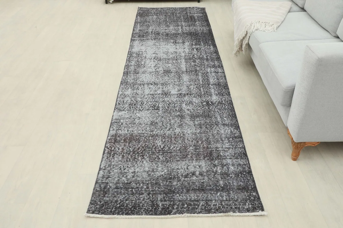 Full length view of the charcoal runner rug laid out in a room, offering a sense of scale.
