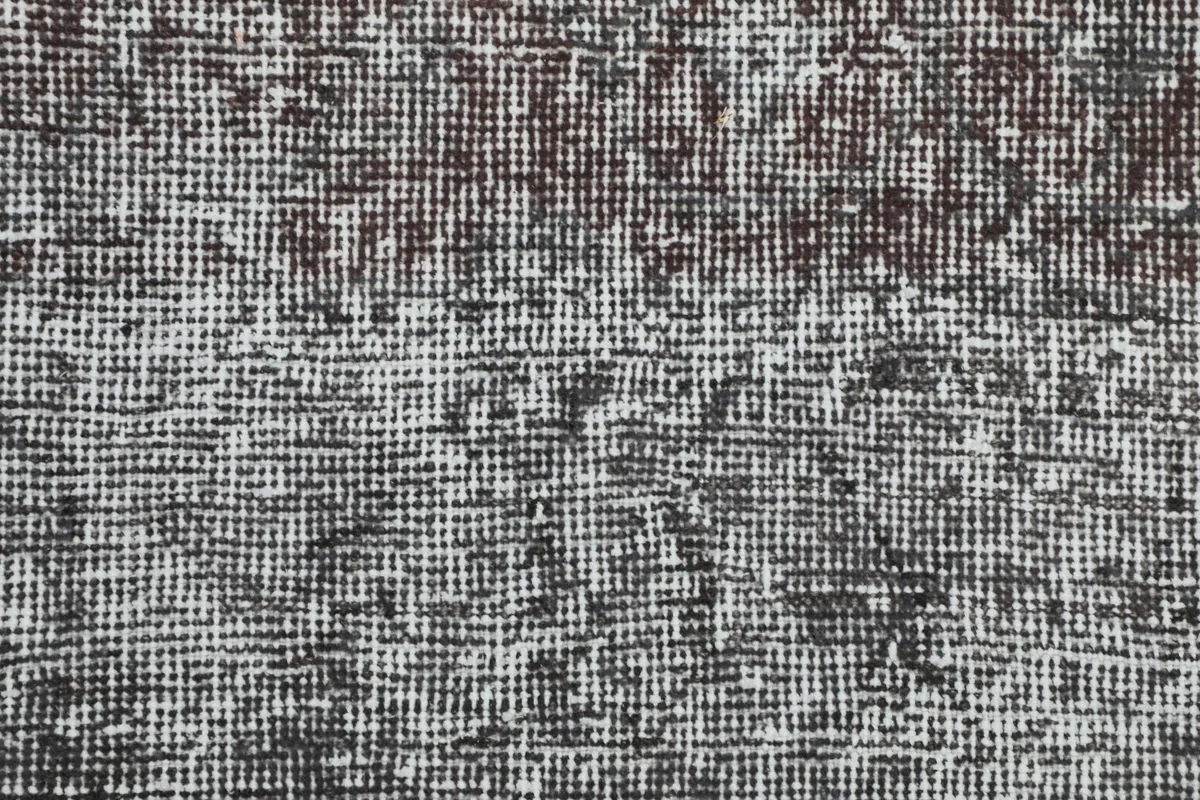 Macro view of the hand-knotted wool pile, showing the tight weave and low height.