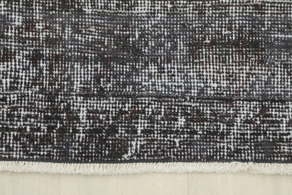 Detail of the rug's end, showing the short, natural fringe and the finished edge.