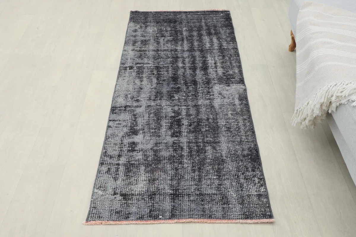 Full overhead view of the charcoal gray runner rug laid out on a light floor