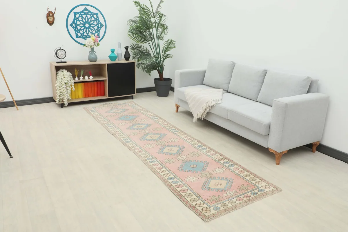 Vintage pink and blue runner rug in a modern living room setting with a light gray sofa