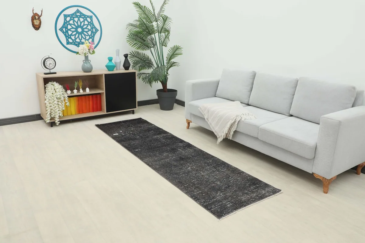 Vintage runner rug in a modern living space with a light gray sofa and wooden cabinet