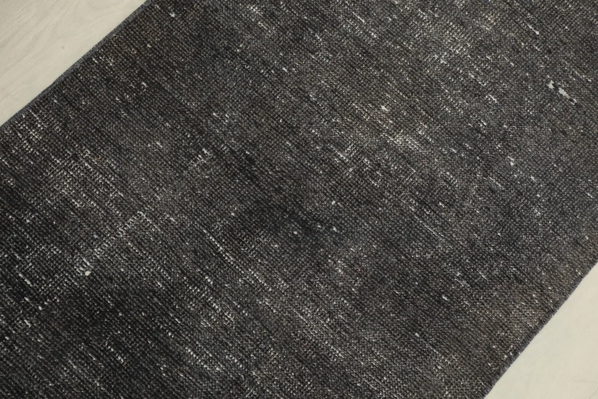 Close-up detail of the faded charcoal pile and subtle texture of the runner