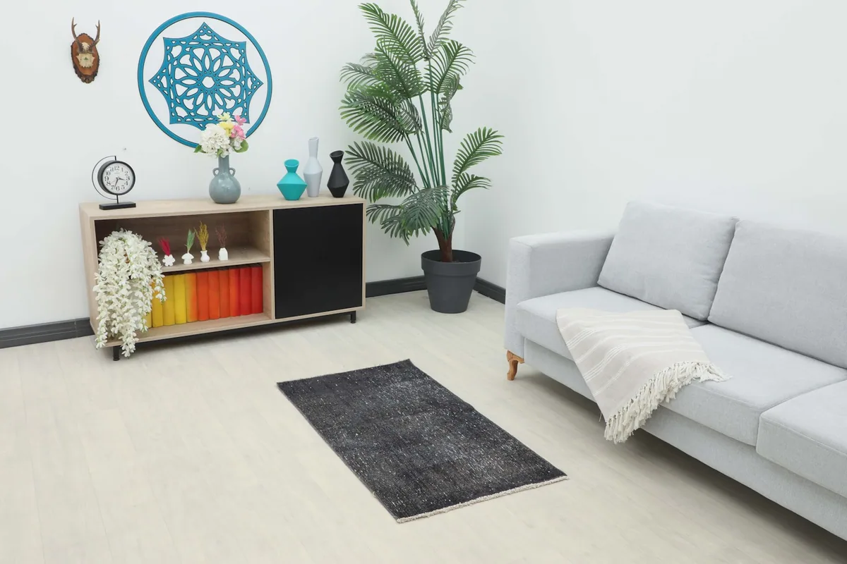Vintage charcoal rug placed in a modern living room setting with a light gray sofa