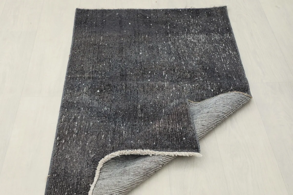 Rug corner folded back, showing the consistent weave of the foundation