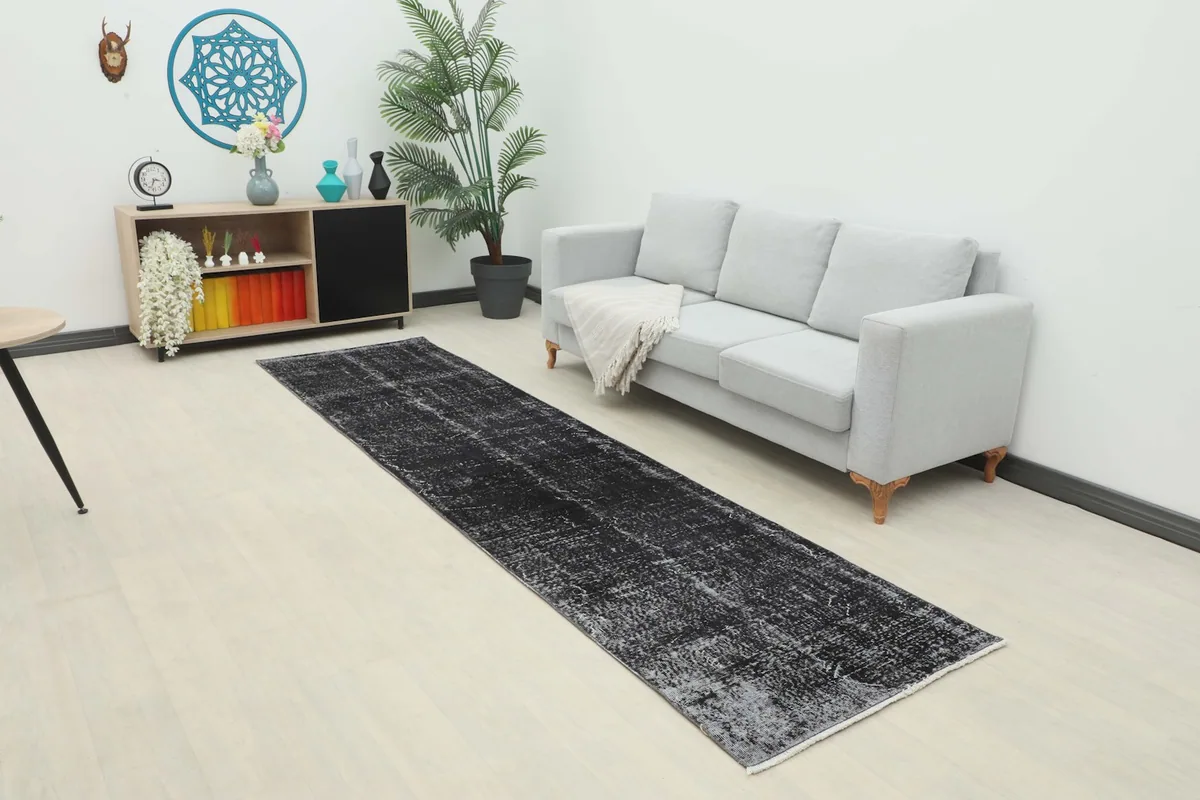 Charcoal runner rug in a modern living room setting next to a gray sofa