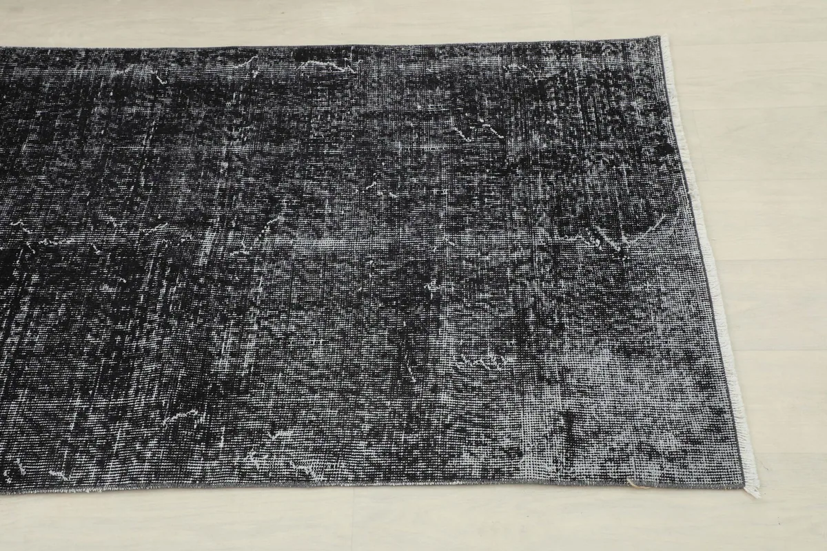 Close-up of the distressed charcoal and gray pile showing subtle pattern variations