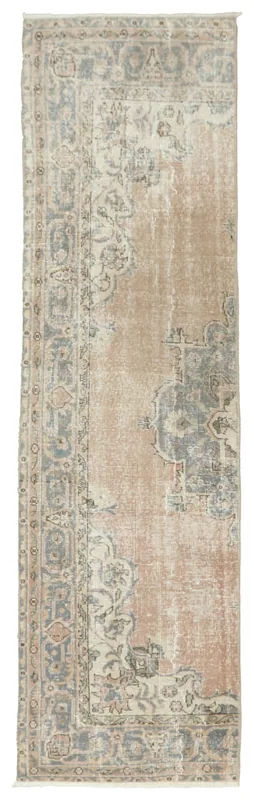 Full overhead view of the tan and blue vintage Anatolian runner on a white background