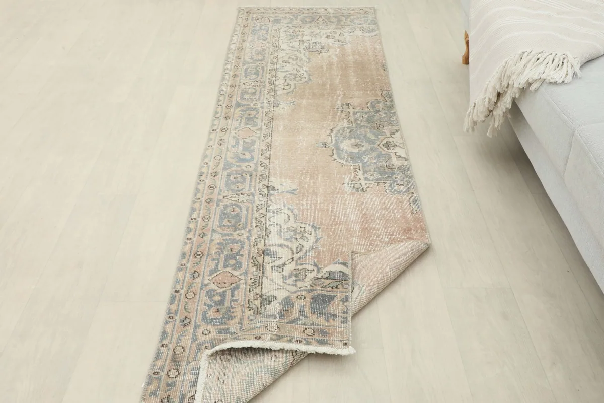 Partial view of the rug's backside, revealing the cotton foundation and hand-knotted construction