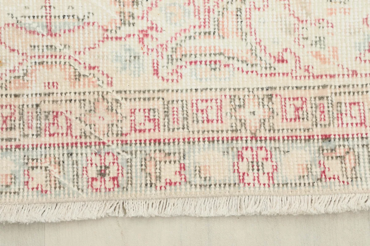 Close-up of the border and fringe of the Rose Ivory Medallion Anatolian Rug, showing hand-knotted detail.