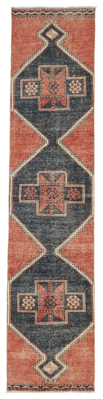 Full overhead view of the rust and navy geometric Anatolian runner rug on a white background