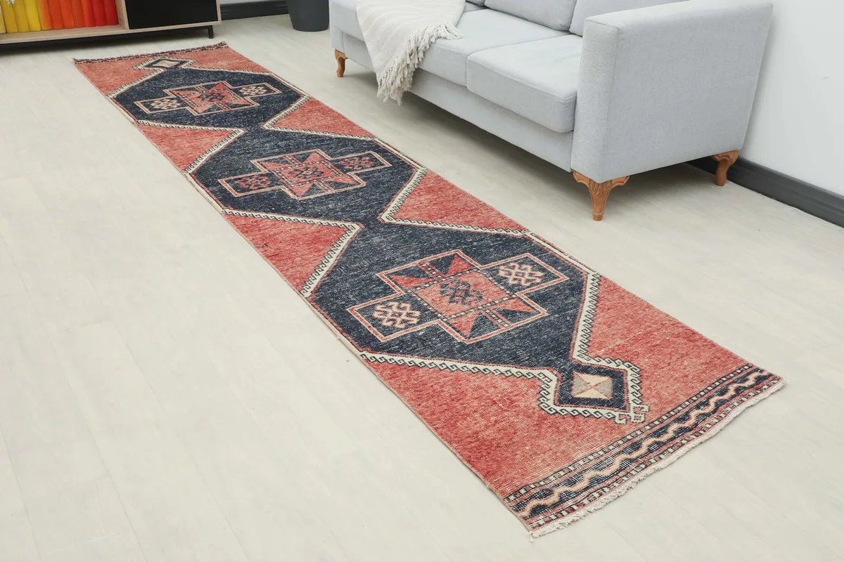 Angled view of the rust and navy runner rug extending into a living space with modern furniture