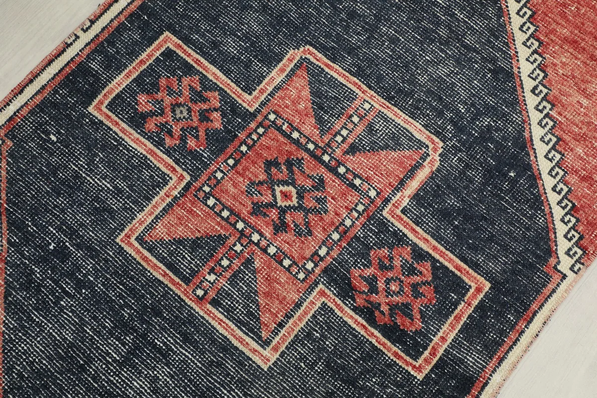 Detailed view of a central navy geometric medallion with rust and ivory accents within the runner
