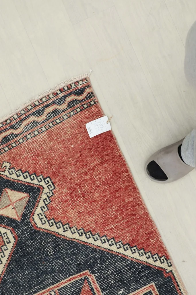 Overhead view of a section of the runner rug with a foot for scale, showing the texture and colors