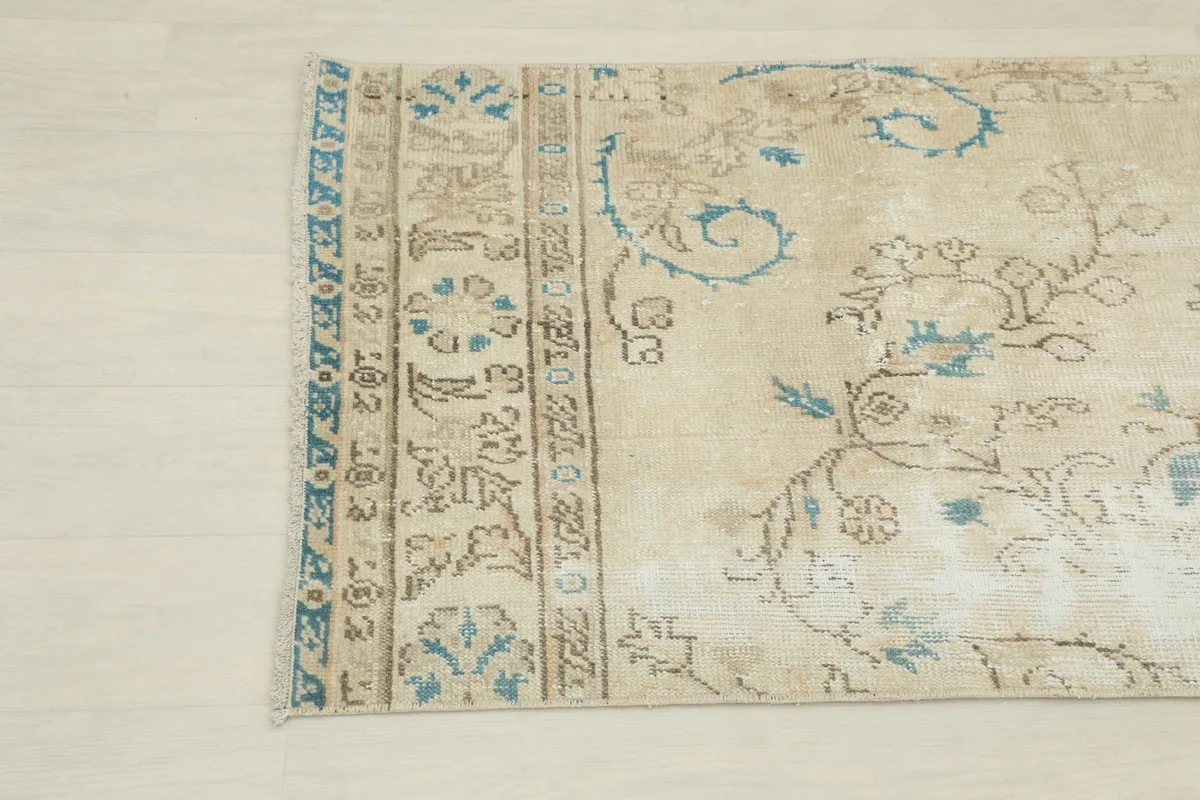 Opposite end of the runner at an angle, displaying the faded blue and brown motifs