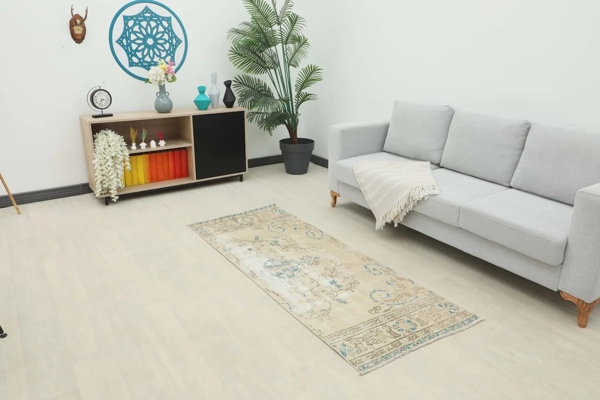 Runner rug displayed in a room setting, showing its scale next to a sofa and cabinet