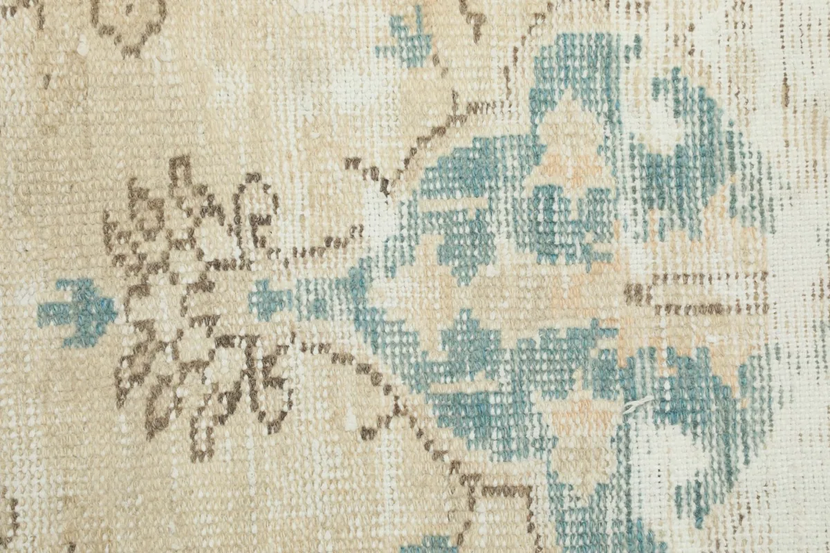 Close-up of the hand-knotted wool pile, showing the texture and colors of the floral design