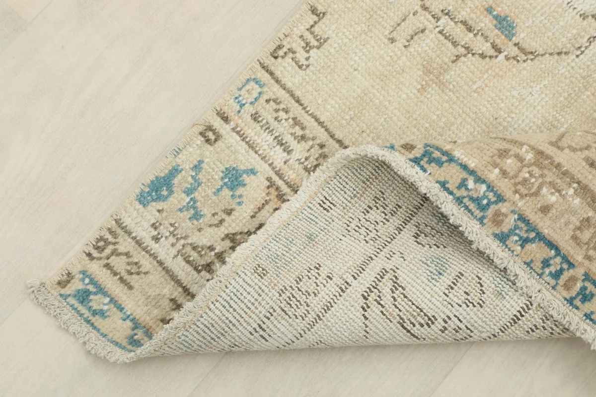 Corner of the runner folded to reveal the cotton foundation and reverse side of the knots