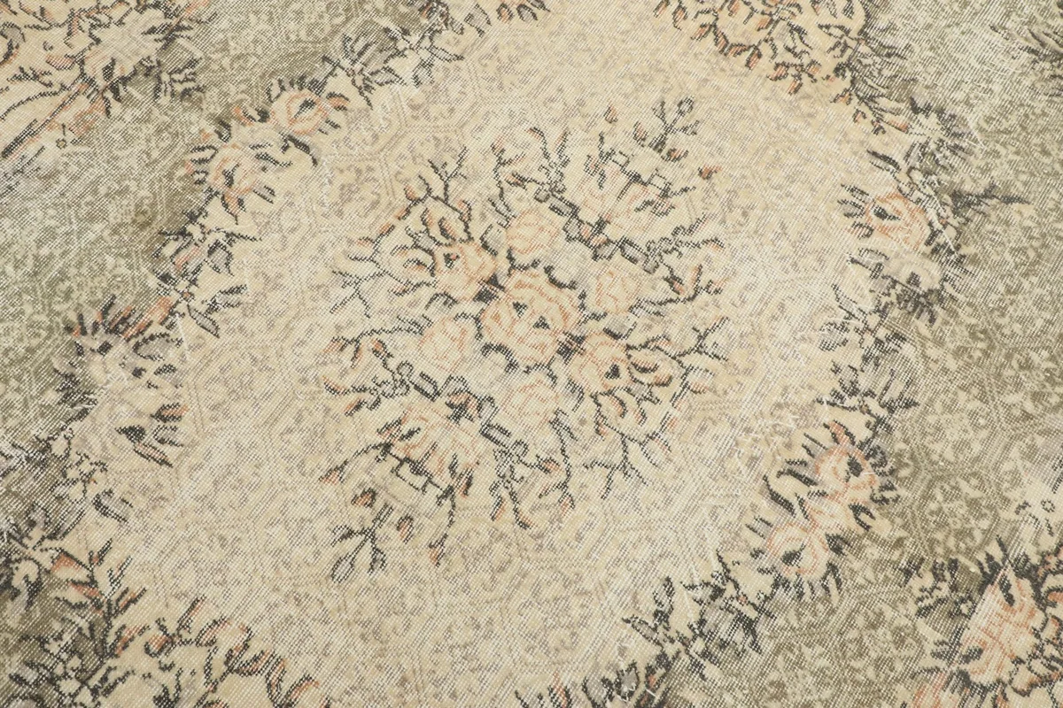 Detailed close-up of the central medallion, showcasing faded rose and gray floral elements.